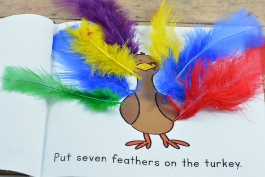 Putting feathers on the turkey in this free printable book.