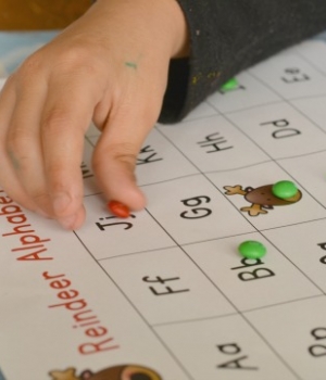 Playing Reindeer Alphabet Bingo with holiday candies. A great Christmas party activity for kids.